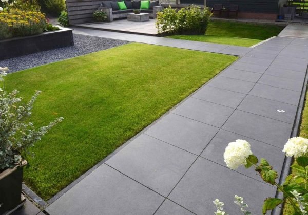Modern patio with high-quality paving slabs and green space.